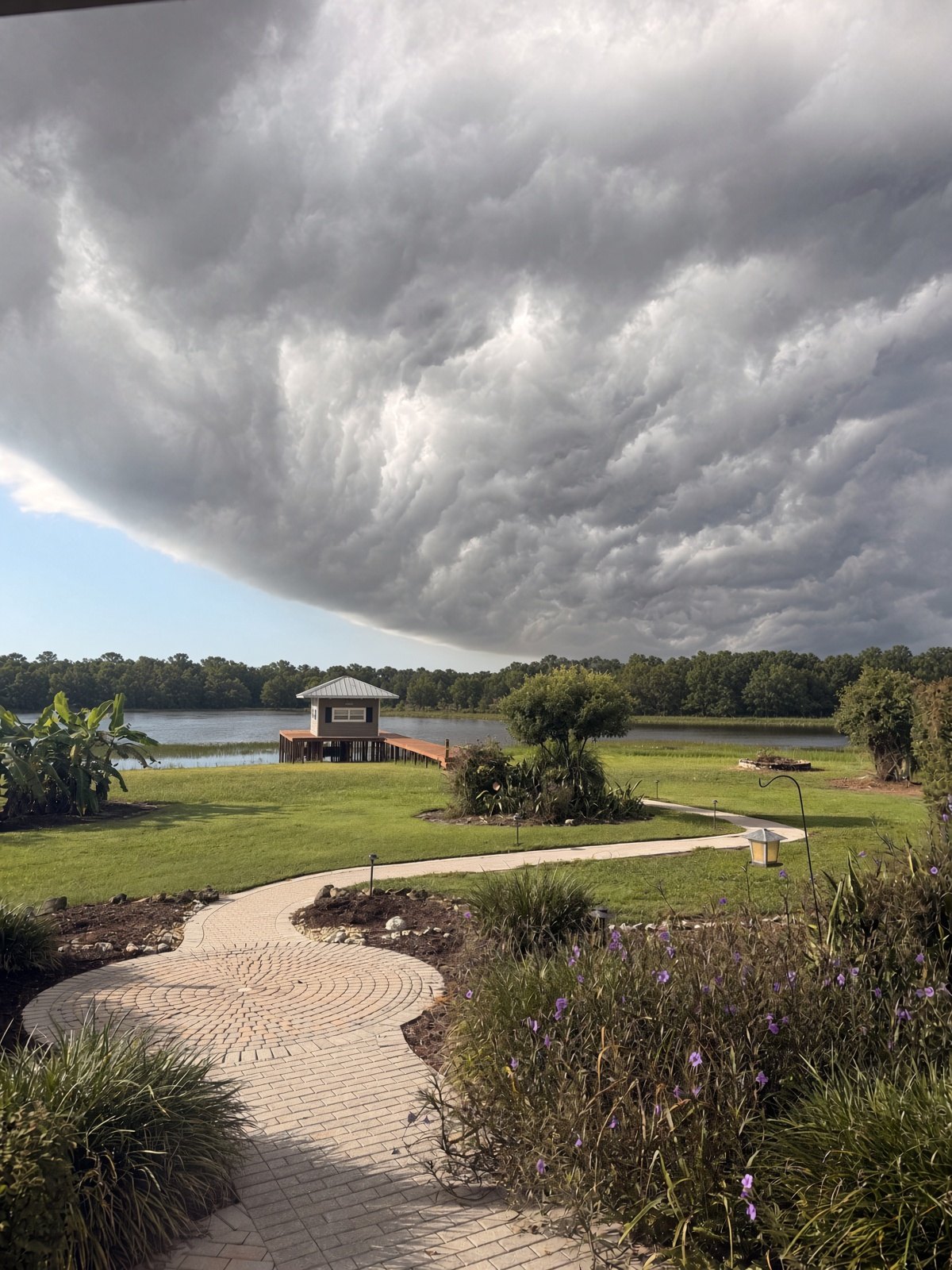 Storm clouds over the lake, the garden path, and the boathouse at Rustin Farms